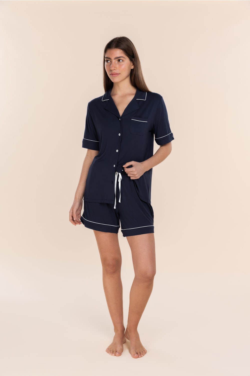 Woman wearing the Sadie Bamboo Short PJ Set in Navy, front view with white contrast piping