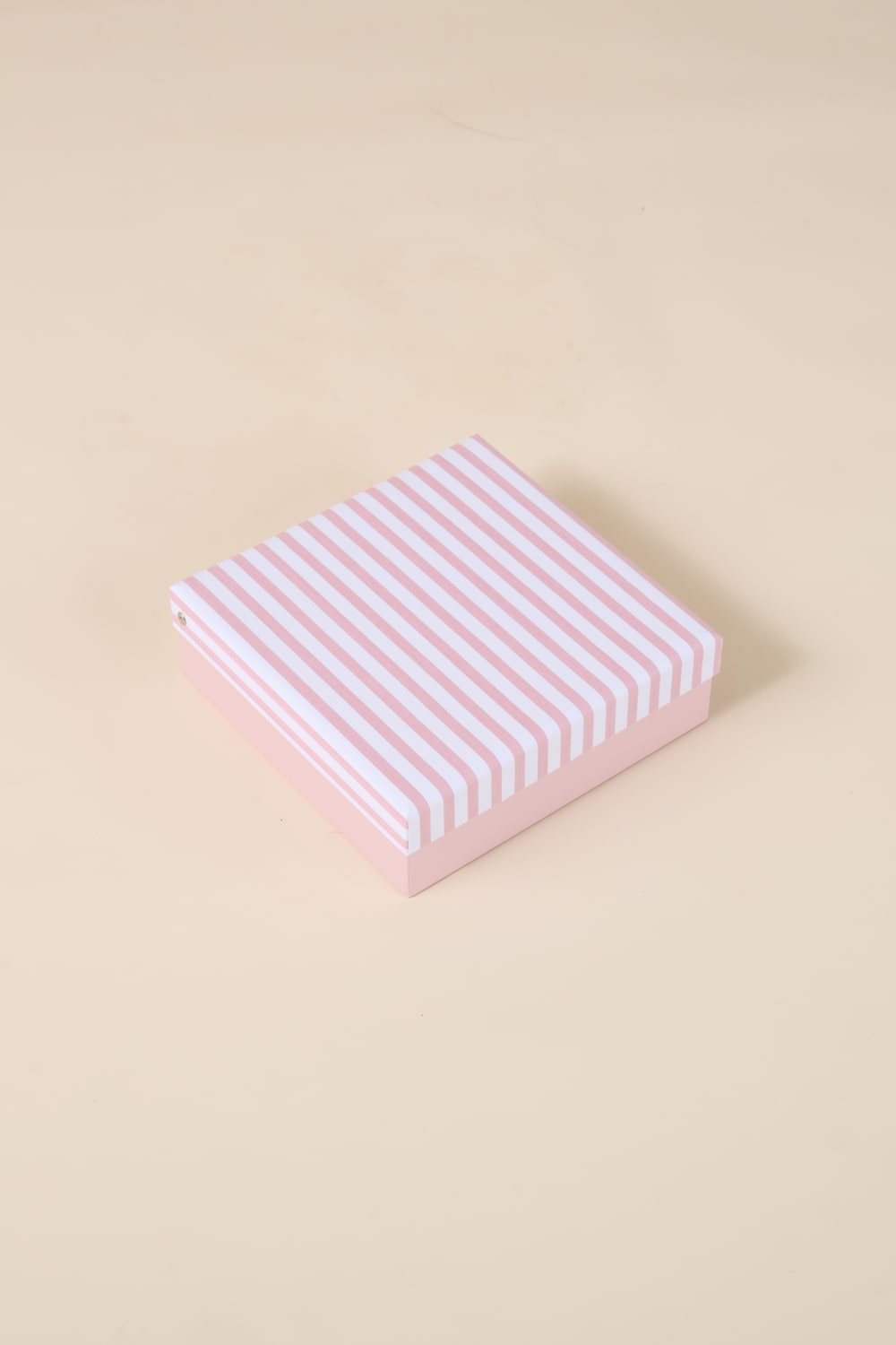 Pink and white striped Gingerlilly Sleepwear gift box on beige background
