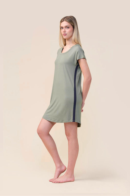 A woman modeling a short-sleeve sage green nightgown with dark navy side stripes, standing against a solid beige studio background.