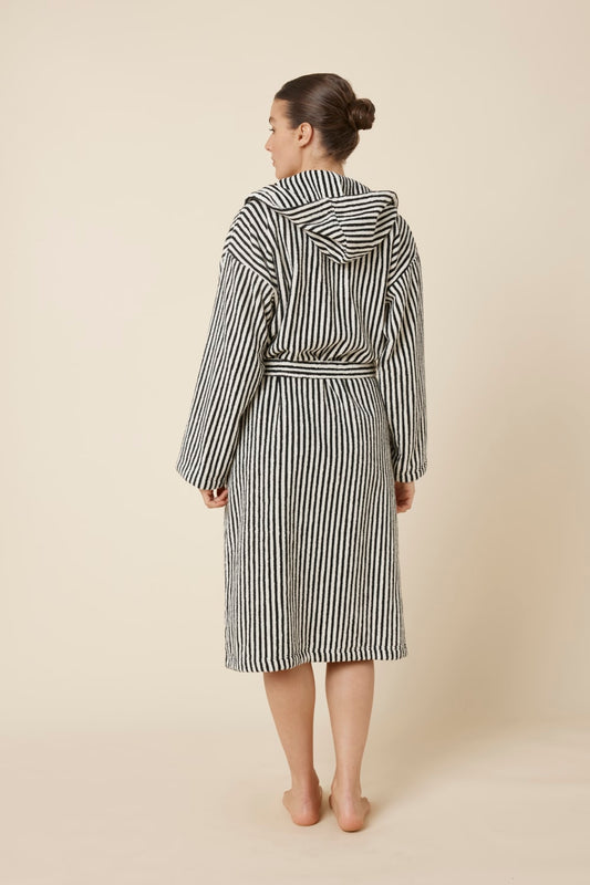 Woman wearing a striped adriana terry towel robe in black colour from back view standing