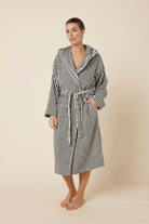 Woman wearing a striped adriana terry towel robe in black colour side on view standing