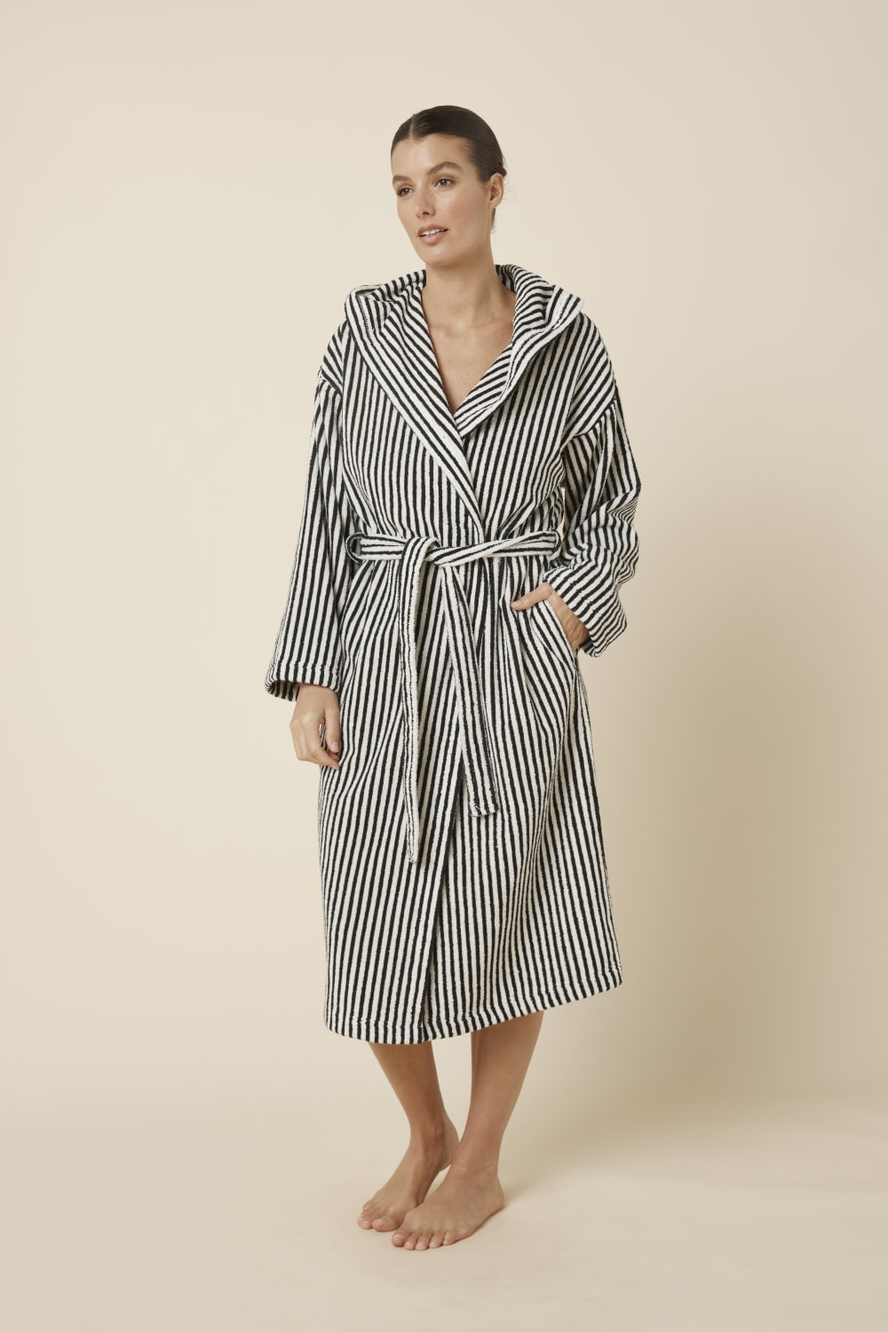 Woman wearing a striped adriana terry towel robe in black colour side on view standing