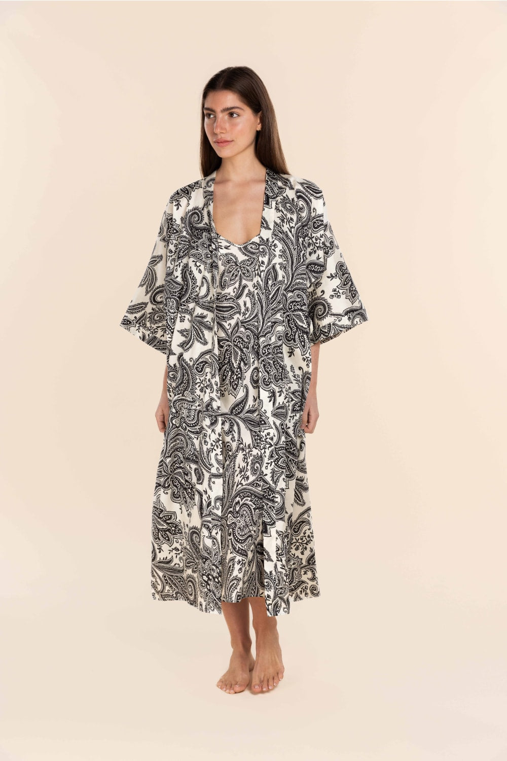 Woman wearing a black and white patterned dress on a beige background