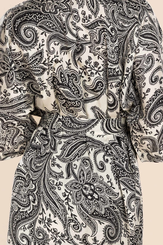 Close-up of a black paisley pattern on a beige background