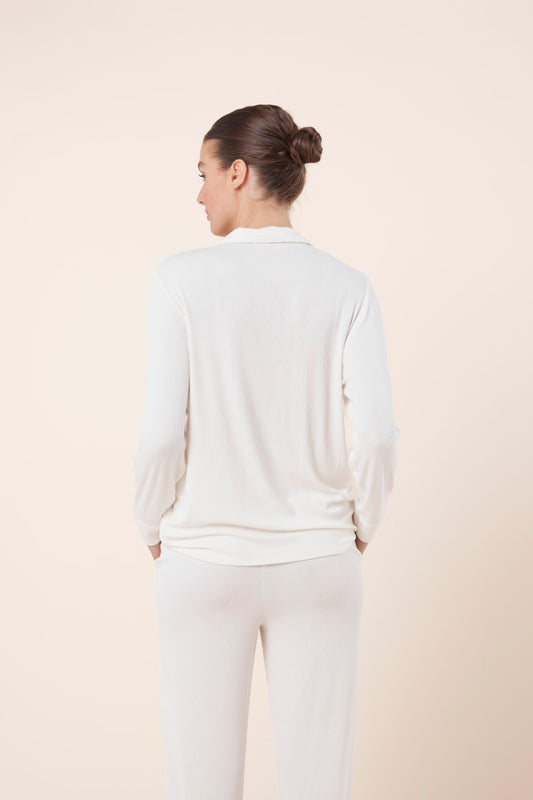 Woman wearing Athens Ribbed Long Pants Ivory, back view styled with coordinating ribbed lounge top