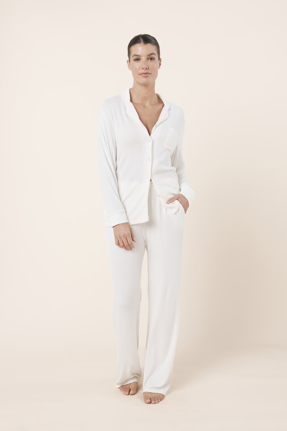 Woman wearing Athens Ribbed Long Pants Ivory, front view of soft ribbed lounge pants with relaxed wide leg fit