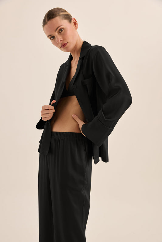 Woman wearing Gingerlilly Sleepwear black pajama set with relaxed fit, side close-up