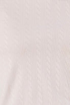 Close-up of a pink textured fabric of the ellie lightweight velour cable knit showing the pattern