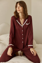 Grace Bamboo PJ Set Burgundy on model sitting, long sleeve bamboo pyjama set with contrast piping and button front detail