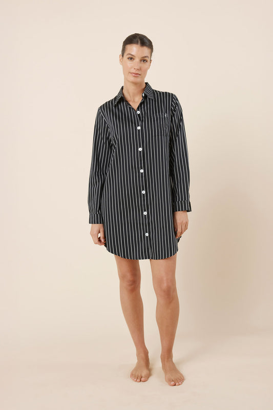 Woman wearing a black and white striped nightshirt on a beige background