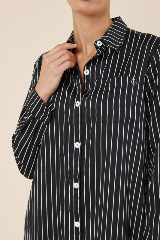 Black and white striped shirt with a brand logo on a beige background