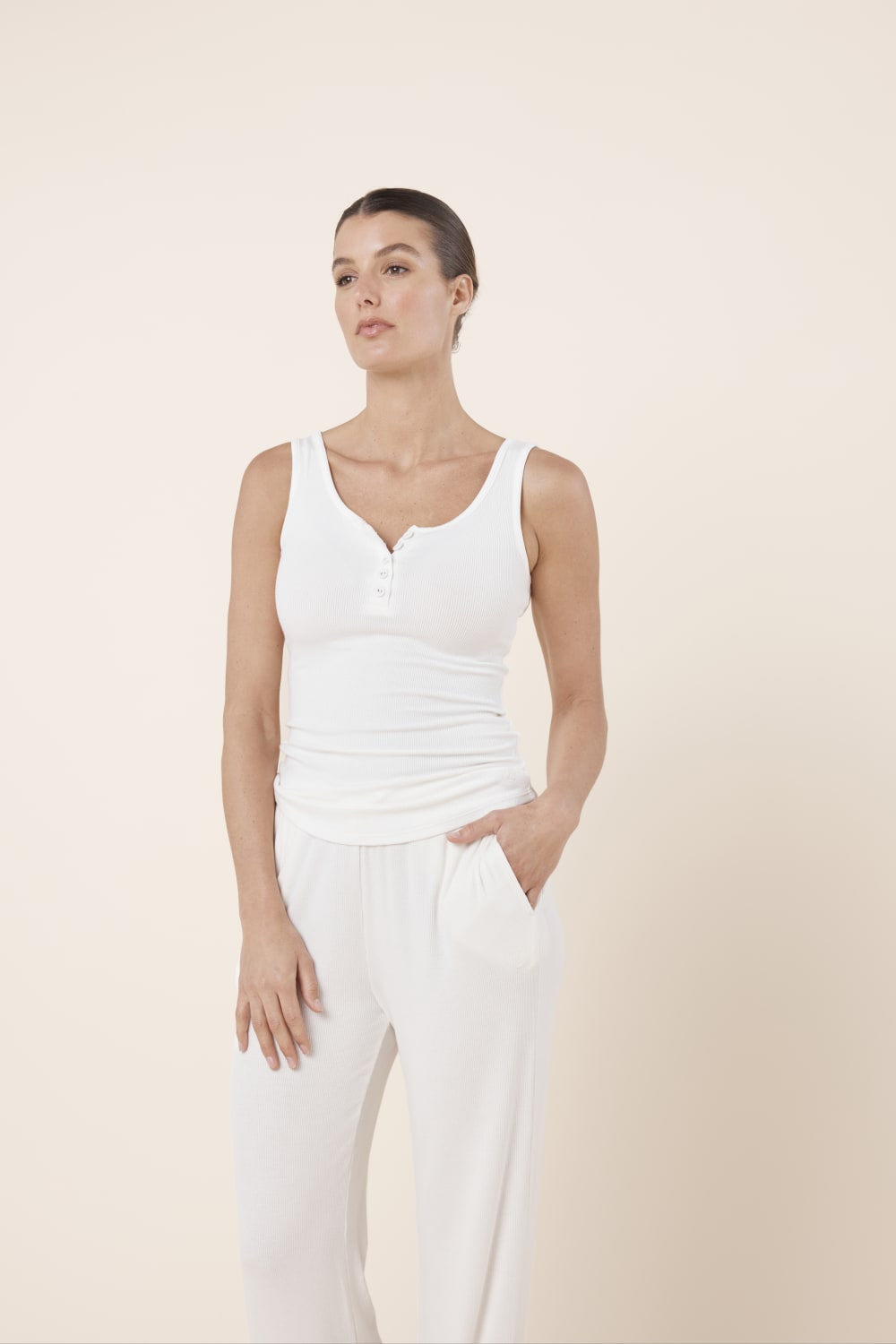 Woman wearing Liberty Ribbed Singlet Henley Top Ivory styled with relaxed ribbed lounge pants