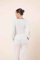 Woman wearing Lille Ribbed Long Sleeve Henley Top Ivory Ecru back view showing slim fit ribbed silhouette