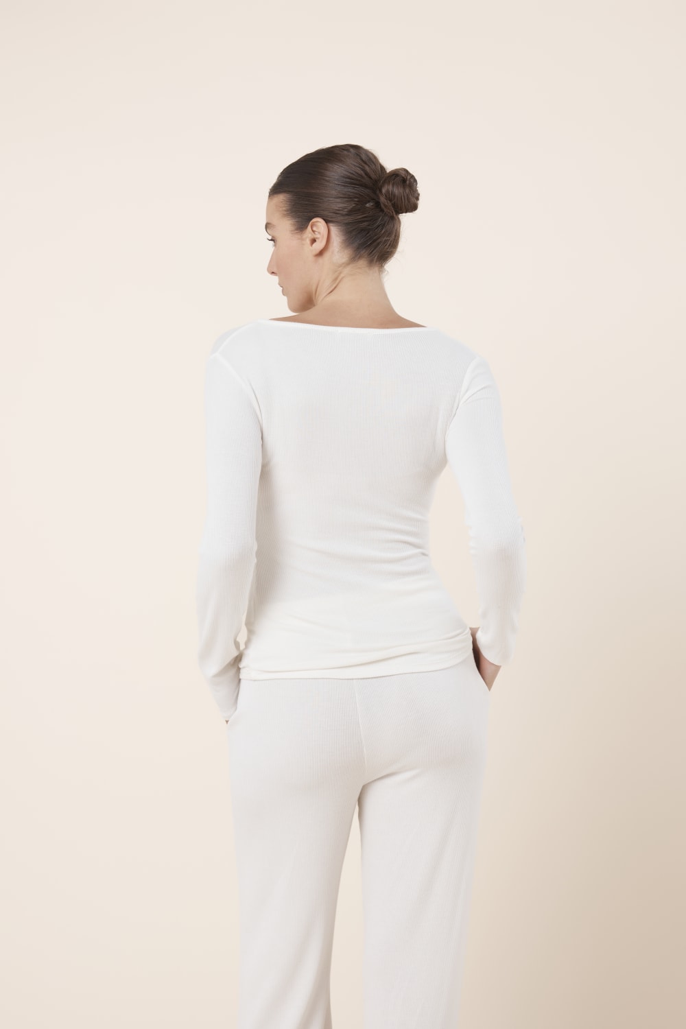 Woman wearing Lille Ribbed Long Sleeve Henley Top Ivory Ecru back view showing slim fit ribbed silhouette