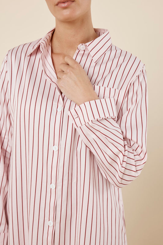 Woman wearing a pink striped Lolita Stripe Night Shirt dress against a beige background front on close view with arm near neck