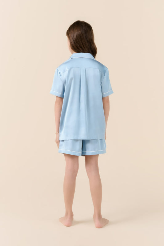 Girl wearing light blue Gingerlilly Sleepwear short pajama set, back view on beige background