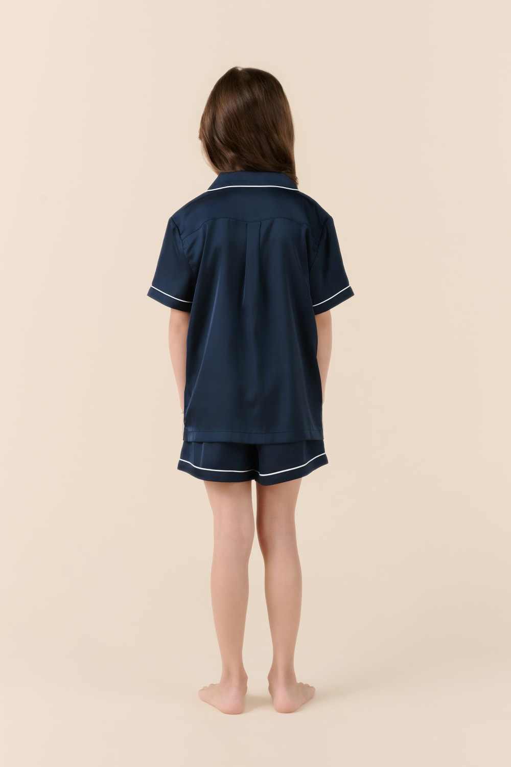 Child wearing navy Gingerlilly Sleepwear short set with white piping, back view