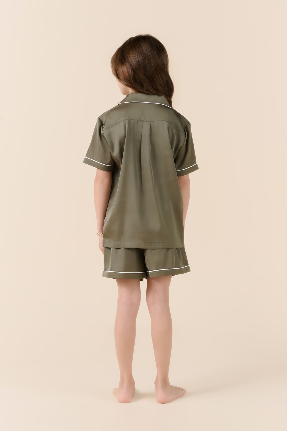 Child in olive green Gingerlilly Sleepwear short pajama set, back view, on beige background