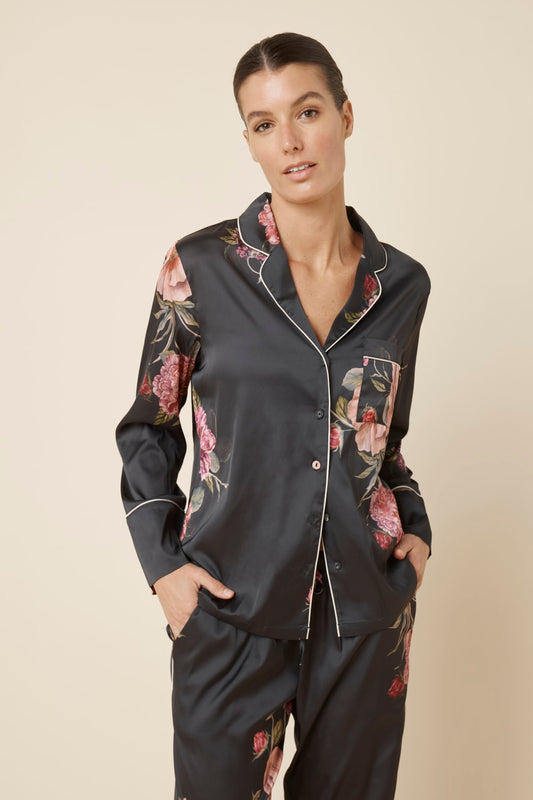Woman wearing a Ruby Floral Satin PJ set black colour front top view on a beige background