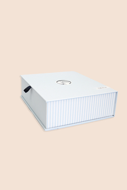 White rectangular box with a brand logo on a beige background