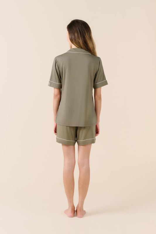 Person wearing a green pajama set on a beige background