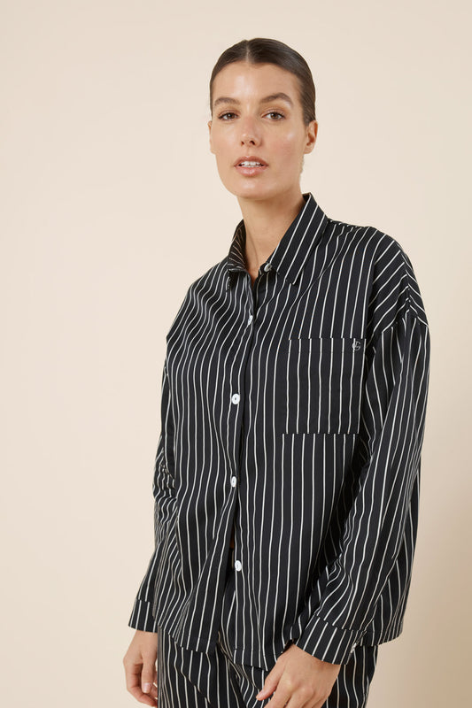 Woman wearing a black and white striped shirt against a beige background
