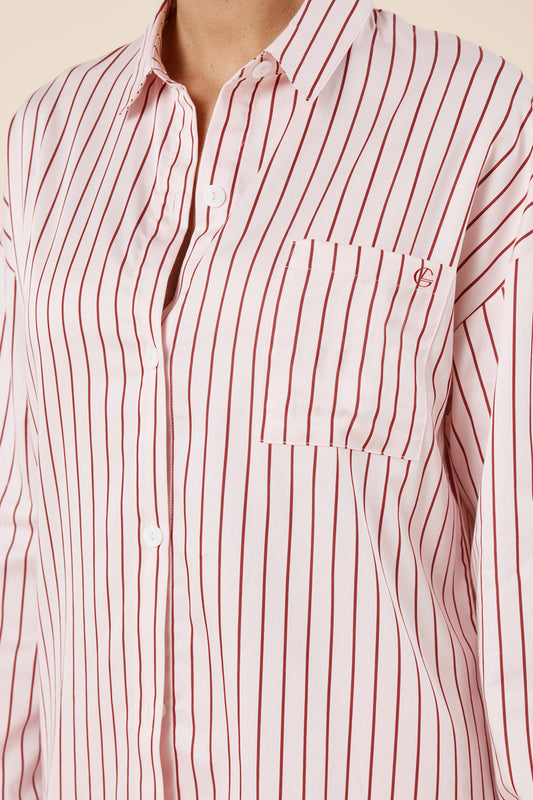 Close-up of a red and white striped shirt with a brand logo on a beige background