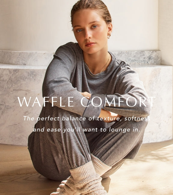 Woman sitting on a staircase wearing waffle-textured clothing with text 'Waffle Comfort' above.