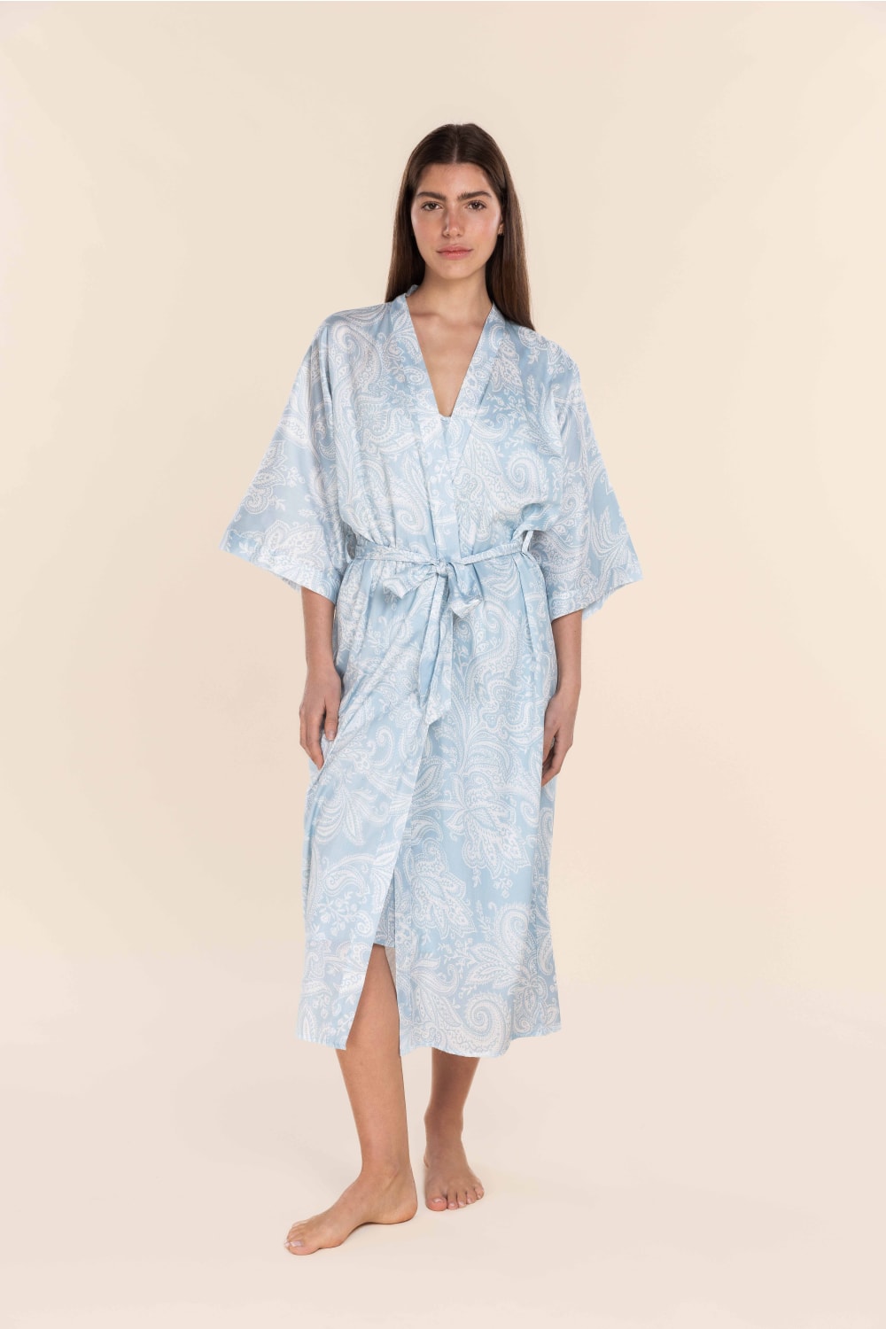 Woman wearing a light blue patterned robe on a beige background