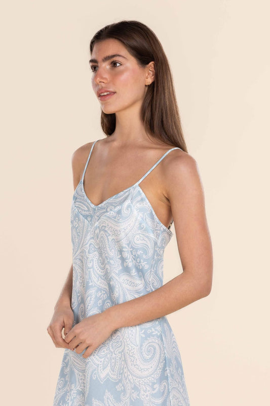 Woman wearing a light blue floral dress against a beige background