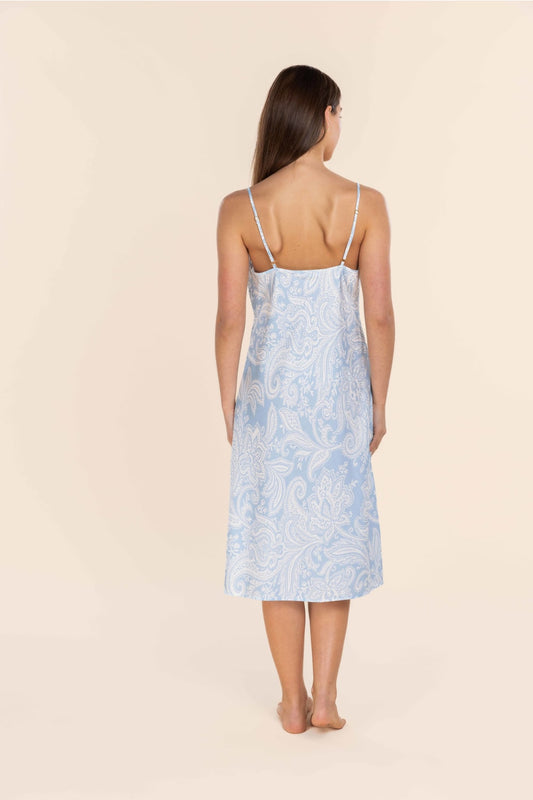 Woman wearing a light blue floral dress against a beige background