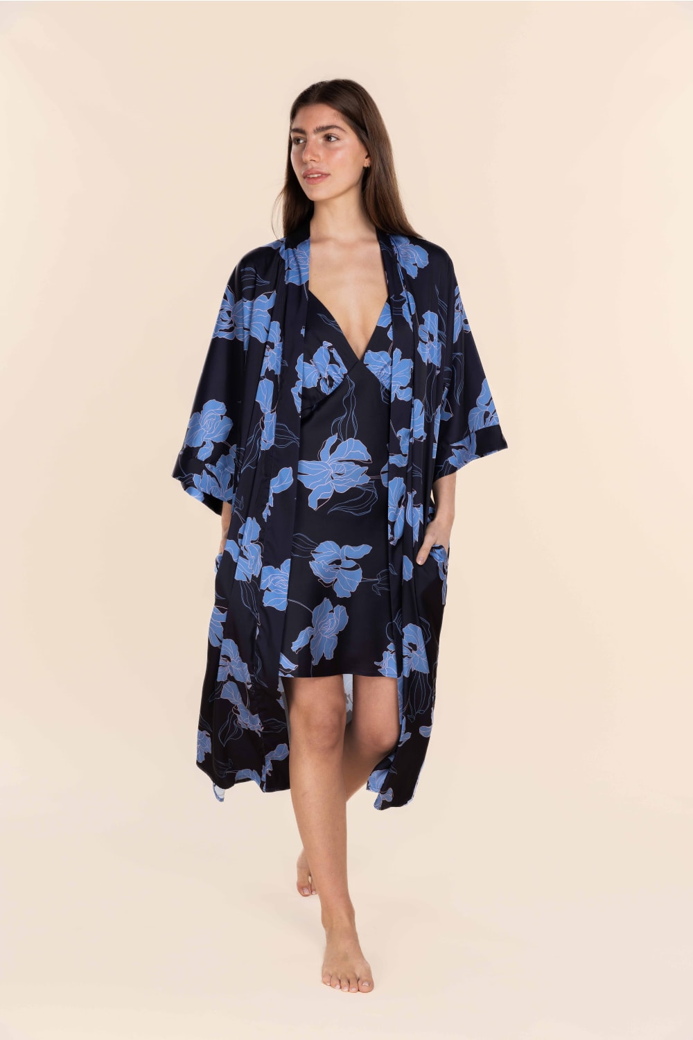Woman wearing a blue floral kimono on a beige background