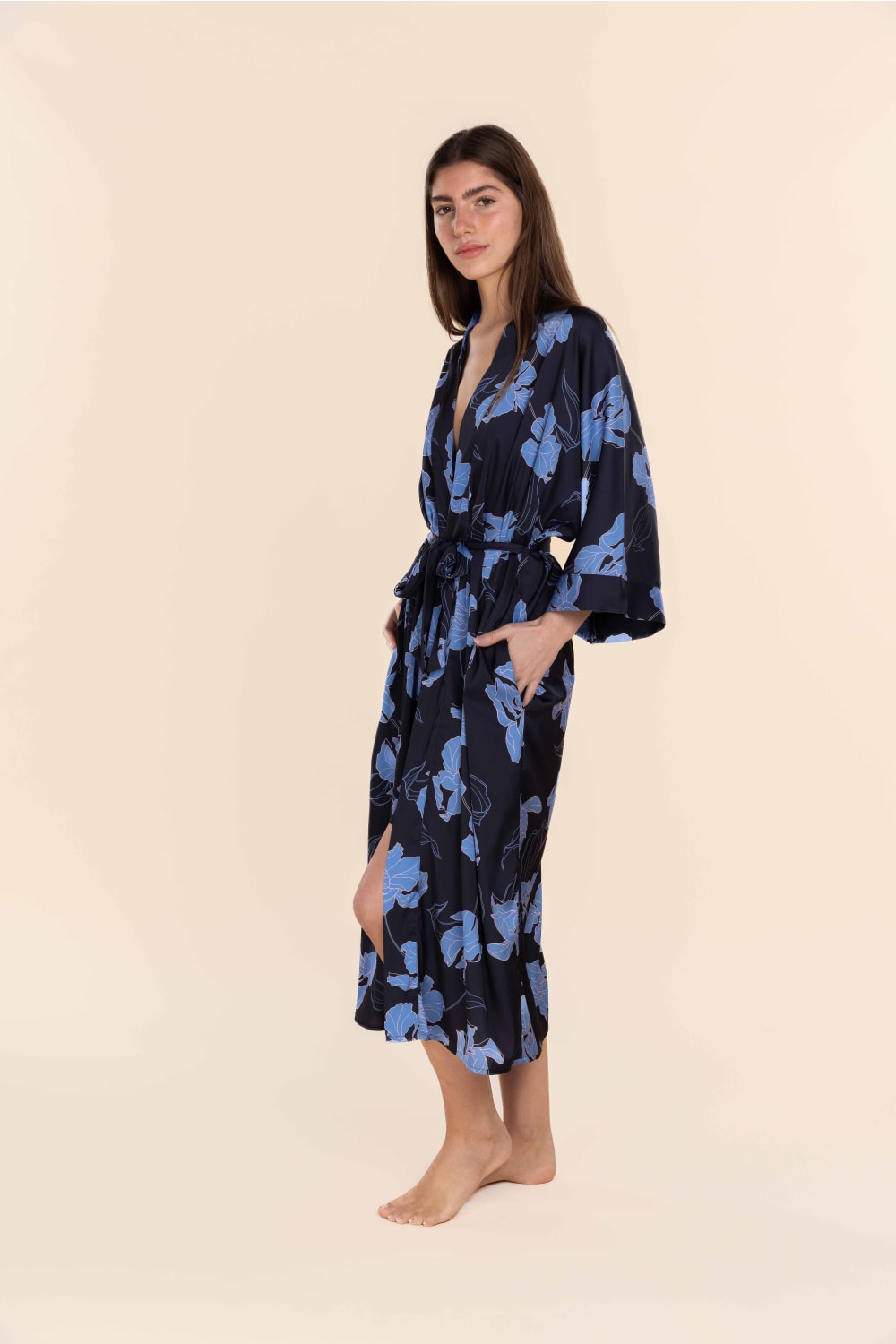 Woman wearing a navy robe with blue floral pattern on a beige background