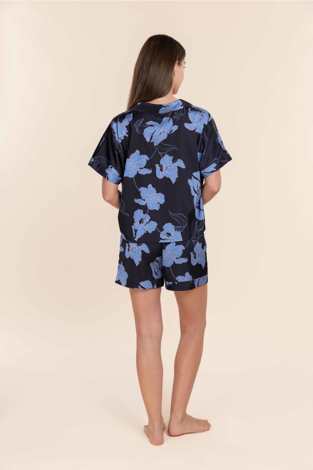 Woman wearing Gingerlilly Sleepwear navy floral short pyjama set, back view.