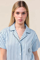 Woman wearing the Lisa Stripe Long Pant PJ Set in Blue, close front view of collar and embroidered logo