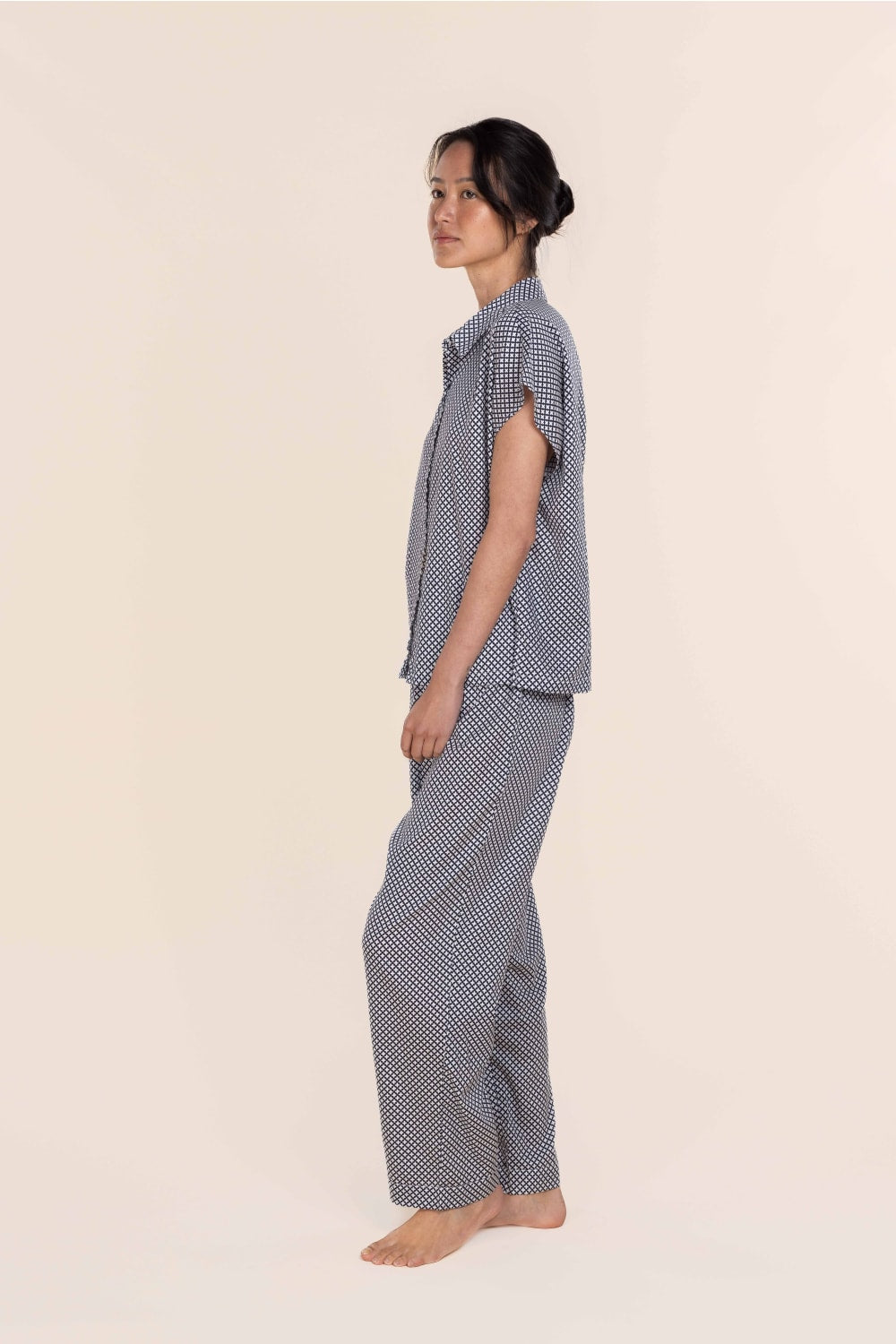 Woman wearing a blue checkered outfit on a beige background