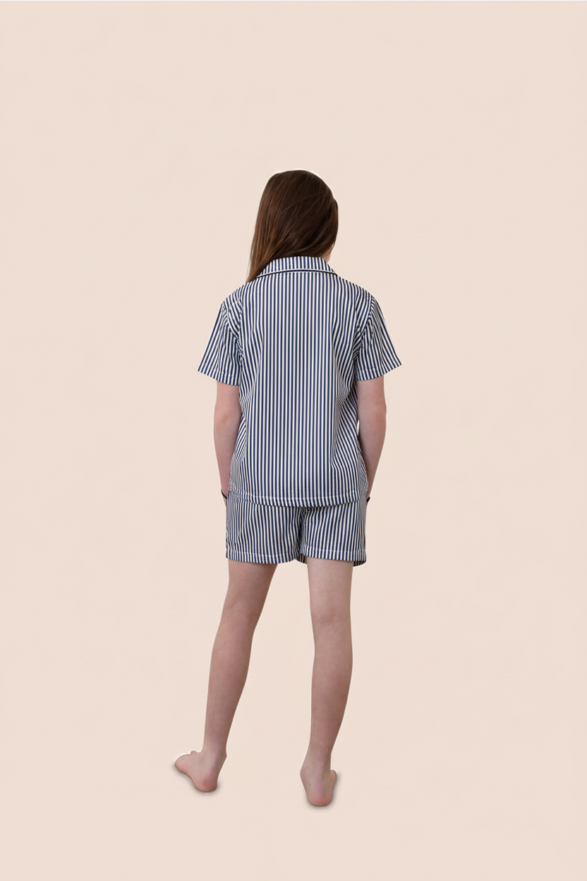 Person wearing a blue and white striped pajama set on a beige background