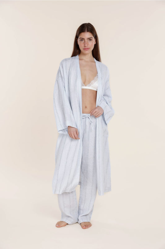 Woman wearing a light blue striped robe on a beige background