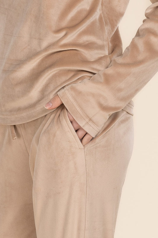 Beige sweatshirt and pants worn by a person, with a neutral background
